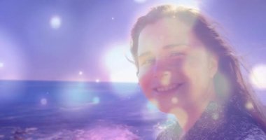 Açılışta gülümseyen bir kadın, gözlerini kapayarak sahile bakıyor. Işıl ışıl parıldıyor. Dinginlik, rahatlama, doğa, huzur, farkındalık, yolculuk, sükunet.