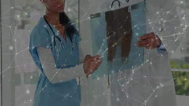 Doktorlar tıbbi bulguları gösterirken hemşire pencerenin yanındaki filme giriyor. Tıbbi, işbirliği, tanı, teknoloji, sağlık, profesyonel, takım çalışması