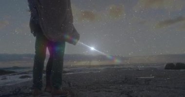 Seyahat eden çift eşlerini sırtlarına alıp şafak vakti ufka doğru yürürken kayalık sahilde taşıyorlar. Romantizm, macera, manzara, doğa, çift, gün doğumu, açık hava