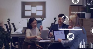 Üç meslektaş dizüstü bilgisayarı açıyor ve ekip incelemesi sırasında finans verilerini gösteren animasyon çizelgelerine neden oluyor. İşbirliği, takım çalışması, veri görselleştirme, modern ofis, şirket, beyin fırtınası, analiz