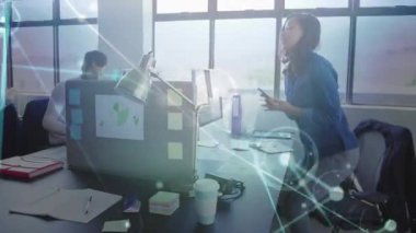 Mavi tişörtlü kadın akıllı telefonu seçiyor ve veri kaplamalı teknolojik güncellemeler için aramaya başlıyor. İşbirliği, iletişim, dijital, yenilik, profesyonel, modern, takım çalışması