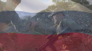 Asker yoldaşa yaklaşıyor ve askeri devriye için tüfeklerle kayalık yamaçtan yukarı çekiyor. Dayanıklılık, takım çalışması, dayanıklılık, taktik, açık hava, dayanıklılık, kararlılık