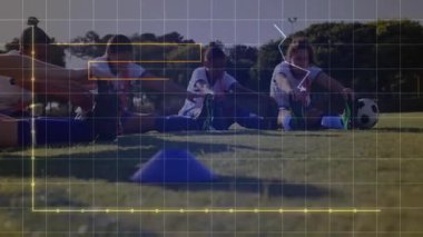 Futbol oyuncuları koni sinyalinde bar çizelgeleri ve çizgi grafiğini göstererek antrenmanda bacak esnetme hareketleri yapıyorlar. Sporcular, takım çalışması, fitness, açık hava, spor, egzersiz, güç