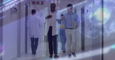 İki doktor hastane koridorunda yürüyor, tableti tıkırdatıyor ve canlandırılmış hasta verilerine bakıyor. Tıbbi, takım çalışması, klinik, profesyonel, belgelendirme, işbirliği, modern