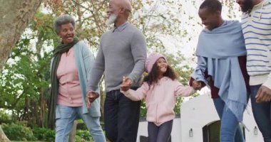 Mutlu Afrikalı Amerikalı ebeveynlerin ve büyük ebeveynlerin bahçede torunlarıyla yürüdükleri bir video. Aile, aile hayatı ve birliktelik kavramı dijital olarak oluşturulmuş video.