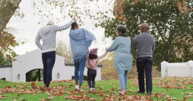 Afrika kökenli Amerikalı ebeveynlerin, büyükannelerin ve torunların bahçede yürüdüklerinin videosu. Aile, aile hayatı ve birliktelik kavramı dijital olarak oluşturulmuş video.