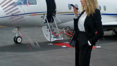 İşletme yöneticisi özel jetin yanında cep telefonuna konuşuyor, veri tartı grafiklerini küresel haritada izliyor. Lüks, şirket, havacılık, iletişim, teknoloji, ağ, zarafet