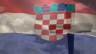 Rüzgar Hırvat bayrağını kaldırıyor, dalgalı kıvrımlar oluşturuyor ve ahşap haç siluetini ortaya çıkarıyor. Vatansever, açık hava, hareket, sembolizm, kumaş, miras, manzara