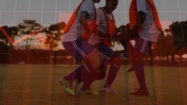 Gün batımının ışıltısı futbol talimini başlatıyor. Üç oyuncu, turuncu önlüklerini giyip çömeliyor. Atletik, takım çalışması, antrenman, fitness, açık hava, motivasyon, spor giyim