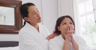 Cüppeli mutlu Asyalı anne ve kızın eğlendiği bir video. Aile, annelik, ilişkiler ve birlikte kaliteli zaman geçirme konsepti dijital olarak oluşturulmuş video.