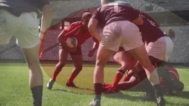 Kırmızı oyuncu, sahada top oynayan takım arkadaşlarını ele veriyor. Donanma yarışması sırasında rugby oyunu oynuyorlar. Eylem, takım çalışması, rekabet, açık hava, atletizm, strateji, yoğunluk
