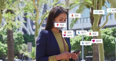 Kaldırımda akıllı telefonları kaydıran bir kadın. Çevirici sosyal medya uyarıları dijital girişleri gösteriyor. Kentsel, teknoloji, sosyal medya, dijital, iletişim, modern, yaşam tarzı