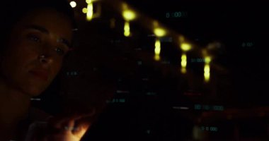 Kadın sicim ışıkları altında tablet ekranı tıklatıyor ve yüzen örtüleri etkinleştiriyor. Analiz kodu. Teknoloji, yenilik, siber, veri, dijital, tefekkür, gece sahnesi