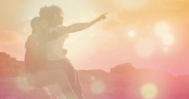 Kadın kolunu kaldırıyor ve ufku işaret ediyor. Günbatımını seyreden gezgin bir çift. Yumuşak güneş ışığı ve bokeh. Romantik, macera, manzara, dinginlik, bağlantı, keşif, manzara