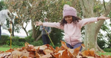 Mutlu Afrikalı Amerikalı baba ve kızının büyükbabasıyla bahçede yaprak topladığı bir video. Aile, aile hayatı ve birliktelik kavramı dijital olarak oluşturulmuş video.