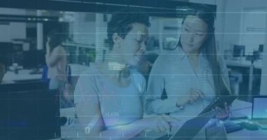 İki teknik analist dizüstü bilgisayarı işaret edip daktilo ediyor, tablet güncelleme kodlarını ve finansal grafikleri kaydediyor. İşbirliği, takım çalışması, yenilik, veri analizi, teknoloji, birlikte çalışma, dijital