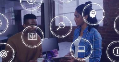 İş arkadaşları tablet kullanıyor ve ekranı tıkırdatırken iş verilerini açıklıyorlar, yüzen simgeler daireler çiziyor. İşbirliği, tartışma, sunum, yenilik, takım çalışması, iletişim, teknoloji