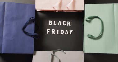 Siyah renkli hediye paketleriyle siyah üzerine beyaz yazılı siyah cuma metni. Kara Cuma, alışveriş, satış ve perakende konsepti dijital olarak oluşturulmuş video.