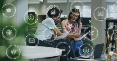 İş arkadaşları iş planlaması için bilgisayarın açılması üzerine dosya ve çizelge simgeleri çeviriyorlar. İşbirliği, takım çalışması, beyin fırtınası, yenilik, modernite, analitik, iletişim