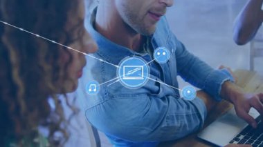 Dizüstü bilgisayarda yazı yazan ve teknoloji ağını işbirliği simgeleriyle donatan ofis arkadaşları. İşbirliği, teknoloji, dijital, çalışma alanı, yenilik, bağlantı, iletişim