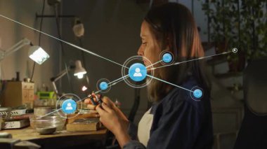 Yetişkin bir kadın ağ simgeleri olarak masa üzerinde ağ oluşturan bileşenleri kaldırıyor ve lehimliyor. Elektronik, işçilik, yenilik, teknoloji, çalışma alanı, konsantrasyon, modern