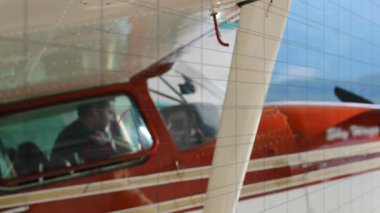 Pilot, kokpit göstergeleri onay beklerken mikrofonu ayarlıyor ve havacılık telsiz katmanı kullanıyor. Havacılık, kokpit, uçak, solo, macera, teknoloji, seyahat