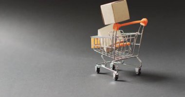 Karton kutularla dolu alışveriş arabaları, kusursuz, fotokopi alanı ile aydınlatılmış siyah arka planlar. Kara Cuma, alışveriş, satış ve perakende konsepti dijital olarak oluşturulmuş video.
