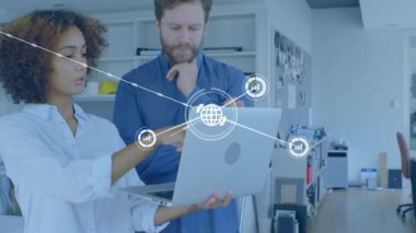 Kadın dizüstü bilgisayardaki teknik verileri analiz ederken, erkek de ağ grafiği ofis genelinde genişliyor. İşbirliği, veri, yenilik, dijital, takım çalışması, profesyonellik, bağlantı