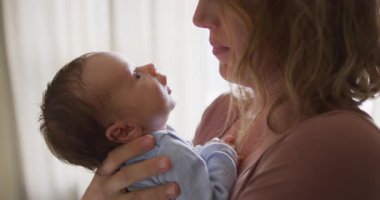 Yeni doğmuş bebeği öpen beyaz bir annenin videosu. annelik, ebeveyn sevgisi ve yeni doğan bebek konseptiyle ilgilenmek dijital olarak üretilmiş video.