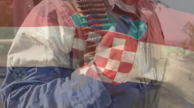 Asker ayak basıyor ve güvenlik için bandocuları sıkıca kavrıyor, ceketi ayarlıyor ve tozlu bölgeyi tarıyor. Askeri, tehlikeli, taktik, açık hava, tetikte, disiplinli, hazır