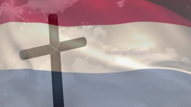 Yumuşak ışık, çapraz silüete neden oluyor ve dalgalanan üç renkli bayrak kontrastı gösteriyor. Anıt, vatanseverlik, sükunet, sembolizm, açık hava, manzara, minimalizm