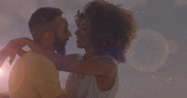 Adam belini tutuyor, öpüşüyor, gülüyor, hareketli güneş ışığı altında sallanıyor. Romantizm, şefkat, bağlantı, yakınlık, günbatımı, açık hava, canlı