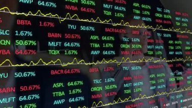 İş arkadaşları, cam saatinin finans verilerini denetleyerek yüzdeleri güncelliyor ve dalgalanan hatları değiştiriyor. Finansal, teknoloji, analitik, dijital, kurumsal, yatırım, borsa