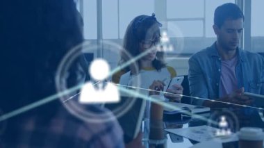 Grup arkadaşları ofis masasında cihazları tıklatarak, ekibi bağlayan animasyon ağ simgeleri oluşturuyorlar. İşbirliği, ağ oluşturma, teknoloji, takım çalışması, yenilik, profesyonel, dijital