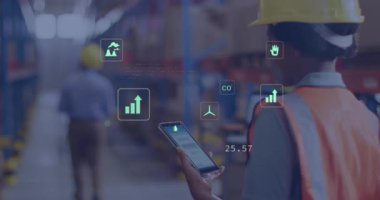 Depo mühendisi telefon ekranını dinliyor ve AR simgelerinin emisyon ölçümlerini güncellediğini gösteriyor. Sanayi, teknoloji, yenilik, sürdürülebilirlik, veri, lojistik, inşaat