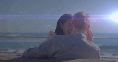 Bir erkek, kadının omzuna sarılıp, samimiyeti ateşliyor, okyanus manzaralı yaşam tarzıyla gülümsüyor. Romantizm, bağlantı, dinginlik, doğal güzellik, mutluluk, deniz kenarı, ilişki