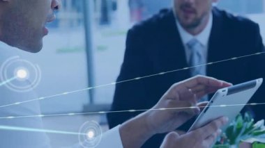 Beyaz gömlekli bir adam tablet tıklatıyor. Meslektaşı izlerken ağ veri görselleştirmesini başlatıyor. Teknoloji, bağlantı, dijital, kurumsal, işbirliği, yenilikçi, veri