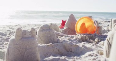 Video of plastic toys lying on sand on beach. Holidays, vacations, relax and summer concept.