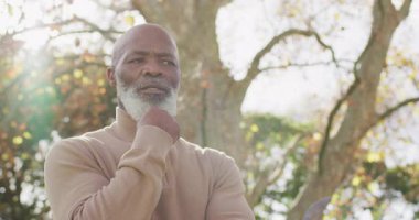 Düşünceli yaşlı Afrikalı Amerikalı adamın bahçede tefekkür ettiği bir video. Emeklilik, ev hayatı, kapsayıcılık, sağlık ve mutluluk kavramı dijital olarak oluşturulmuş video.