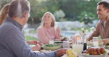 Video of happy caucasian parents, daughter and grandparents talking at outdoor dinner table. Family, domestic life and togetherness concept digitally generated video.