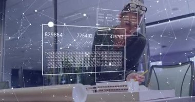 Mimari model üzerine eğilir ve analiz için basılı planlar kullanırken 3D veri örtülerini etkinleştirir. Yenilik, teknoloji, kesinlik, planlama, profesyonel, modern, analiz
