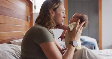 Yeni doğmuş bebekle oynayan mutlu beyaz bir annenin videosu. annelik, ebeveyn sevgisi ve yeni doğan bebek konseptiyle ilgilenmek dijital olarak üretilmiş video.