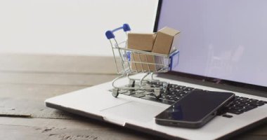 Alışveriş arabasında kutular ve dizüstü bilgisayarda akıllı telefon. Küresel iş, çevrimiçi alışveriş, siber pazartesi, satış ve perakende konsepti dijital olarak oluşturulmuş video.