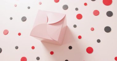 Kırmızı ve siyah noktalı beyaz arka planda pembe hediye kutusu manzarası. Lüks muamele, mevcut, alışveriş, satış ve perakende konsepti dijital olarak oluşturulmuş video.