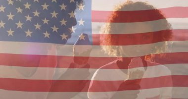 Anne ve oğlunun dondurma külahları tuttuğu yemek reklamı, bayrak altında ikramlar tatmak. Aile, kutlama, vatanseverlik, boş zaman, açık hava, sıcaklık, kaynaşma