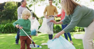 Video of smiling caucasian grandson high fiving grandmother while collecting plastic for recycling. Family, domestic life, togetherness, recycling and waste concept digitally generated video.
