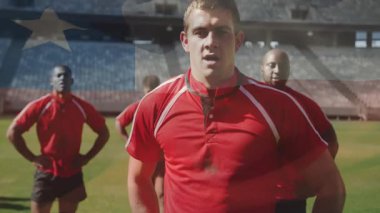 Spor takımı stadyuma adım atarken Amerikan bayrağı birliğin üzerinde kayıyor. Sporcular, takım çalışması, vatanseverlik, adanmışlık, motivasyon, stadyum, yoldaşlık