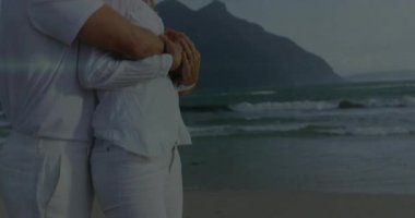 Kameralar kıyıda birbirine sarılan çifti kameraya çekiyor. Sağlık reklamı lenslerini parlatmak için. Romantik, samimiyet, dinginlik, bağlantı, doğa, manzara, uyum