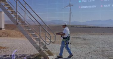 Teknisyen rüzgar çiftliğindeki merdivenlere yaklaşıyor ölçümler yenilenirken emniyet kemeri takıyor ve tırmanıyor. Endüstriyel, teknoloji, bakım, güvenlik, otomasyon, keşif, mühendislik