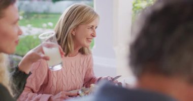Video of happy caucasian parents, daughter and grandparents eating at outdoor dinner table. Family, domestic life and togetherness concept digitally generated video.